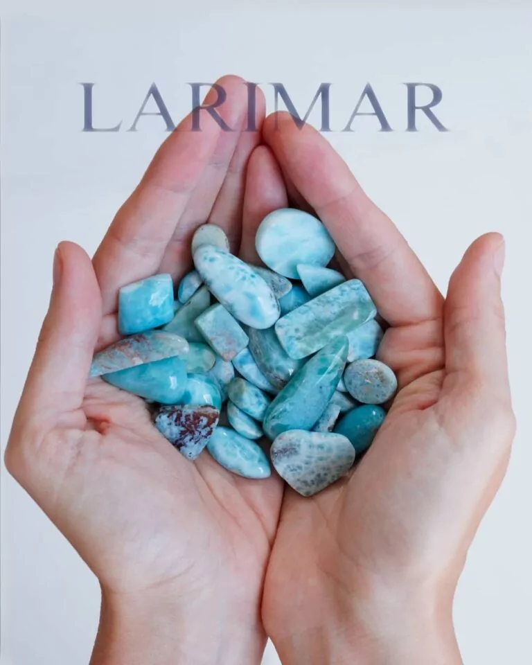 Larimar Trommelsteine auf Frauenhänden mit Beschriftung "LARIMAR". Symbolbild für die spirituelle Bedeutung von Larimar.