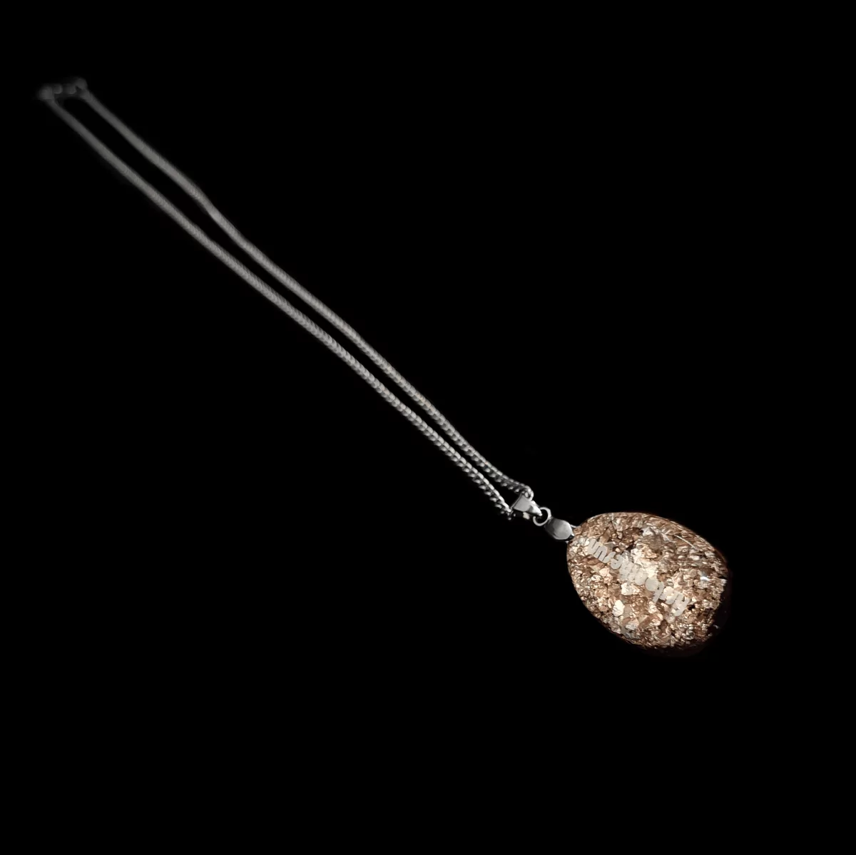 Mit Sterling Silber besetzte Rückseite eines firstonthesun Orgoniten. Befestigt ist dieser an einer silbernen Kette.