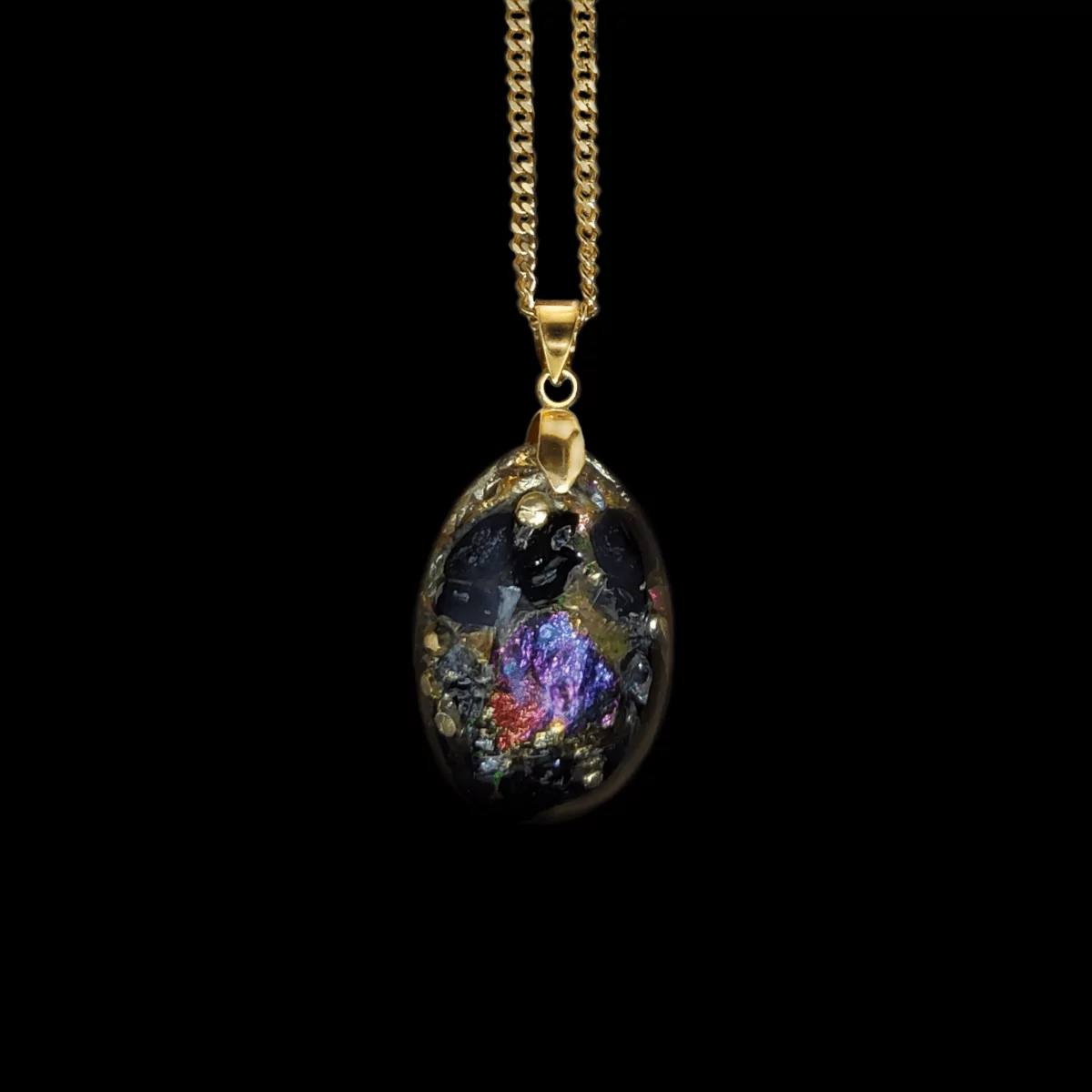 Orgonit Schutz Amulett Anhänger aus Edelsteinen in schwarzer, goldener und bunter Farbe mit goldenem Anhänger und goldener Kette.