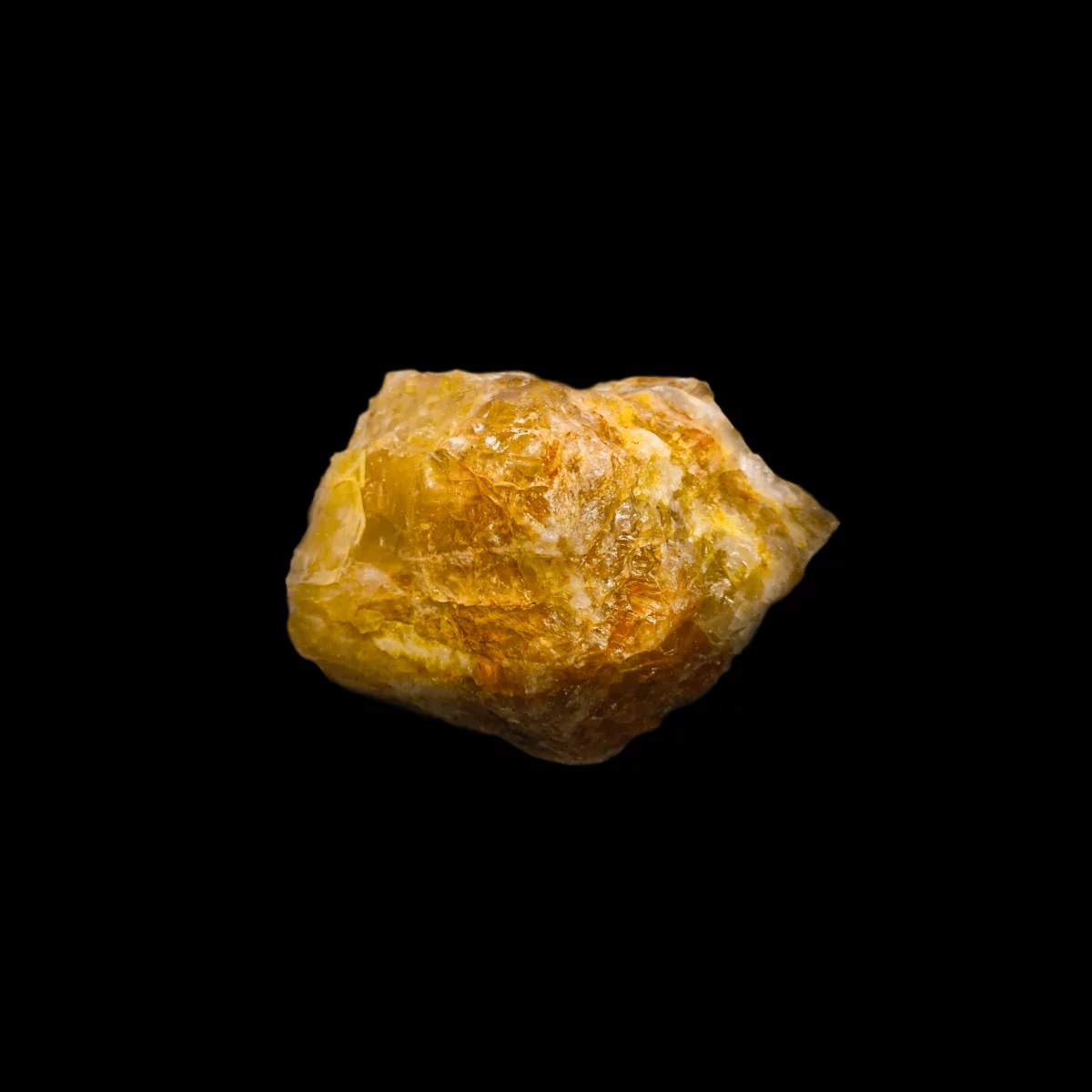 Echter Citrin Rohstein auf schwarzem Hintergrund. Dieser Citrin ist tiefgelb.