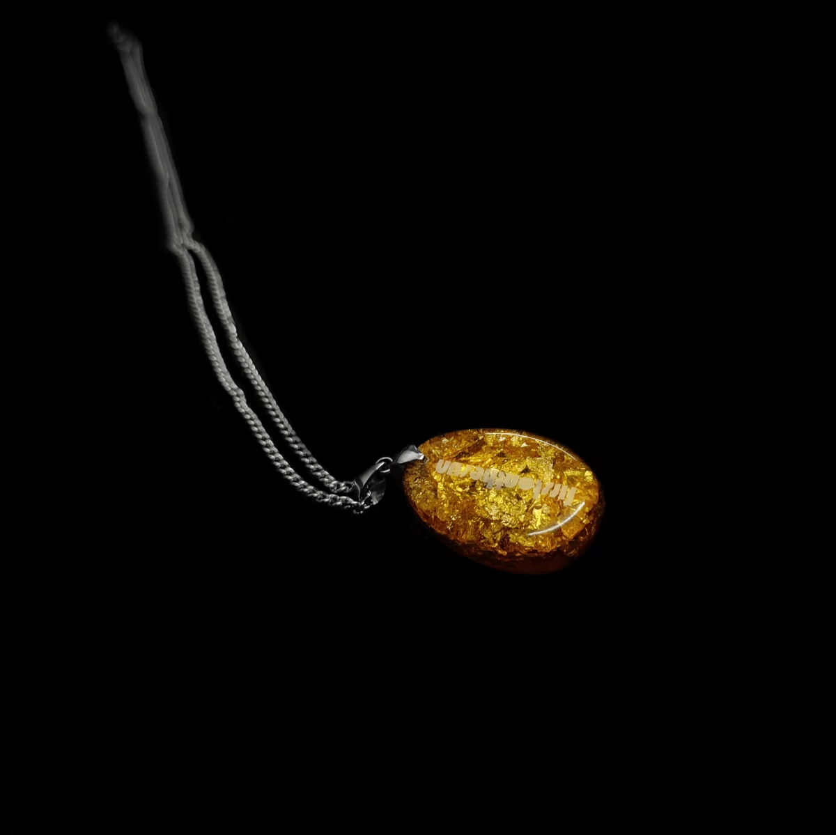 Die Rückansicht eines Orgonit Amuletts. Der Markenname "firstonthesun" befindet sich auf der Rückseite.