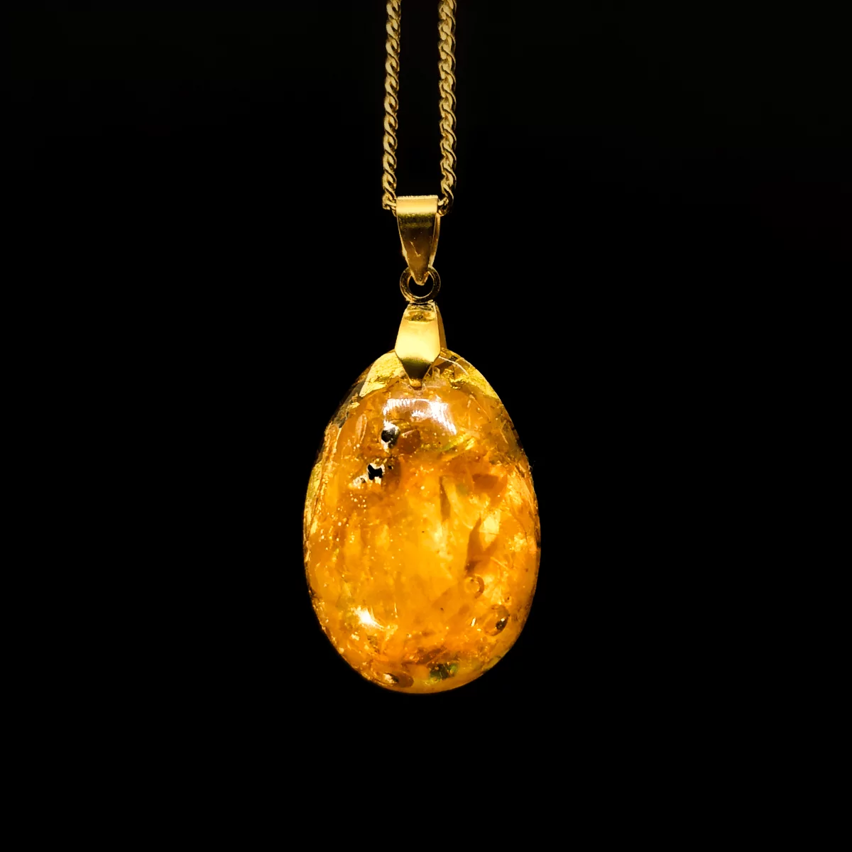 Orgonit Schmuck Anhänger aus Edelsteinen mit Citrin in gelber Farbe mit goldener Collierschlaufe und goldener Kette.