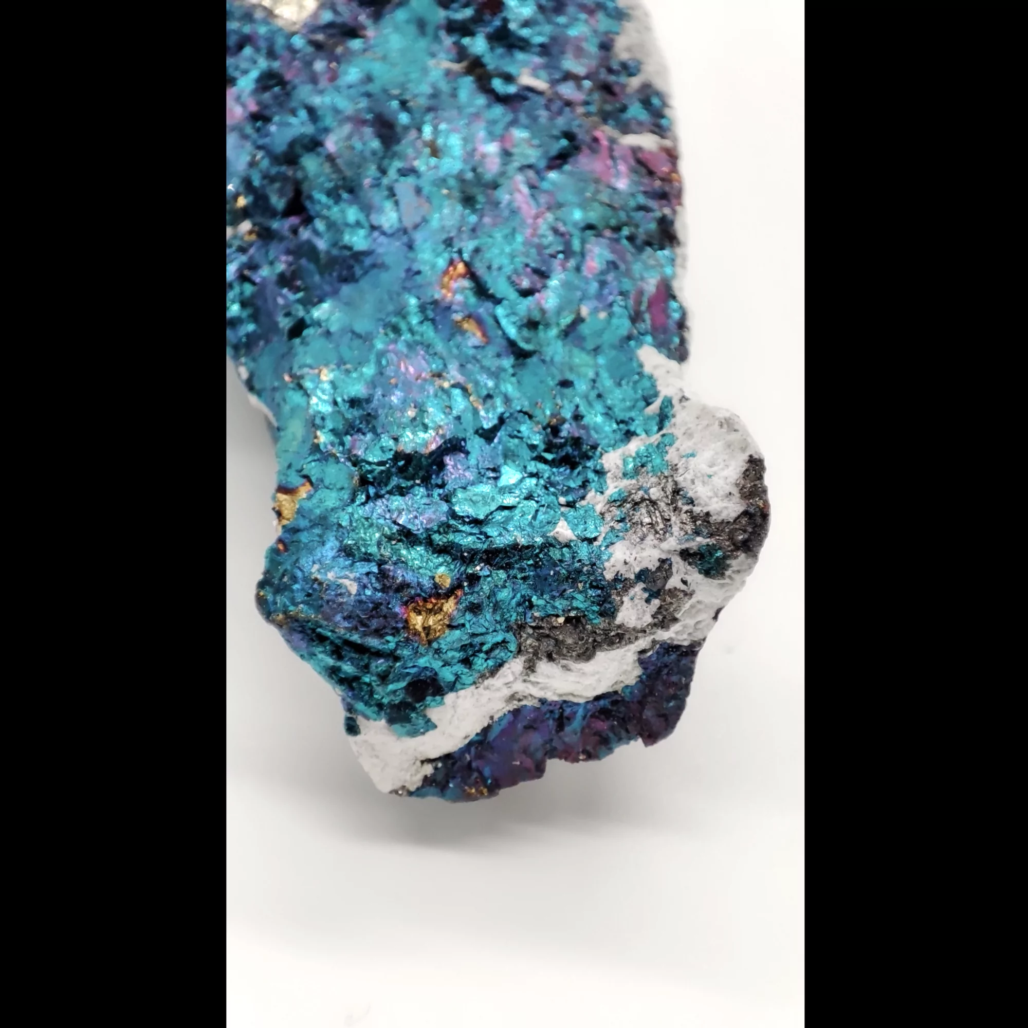 Makroaufnahme eines bläulich grün schimmerndem Chalkopyrits.