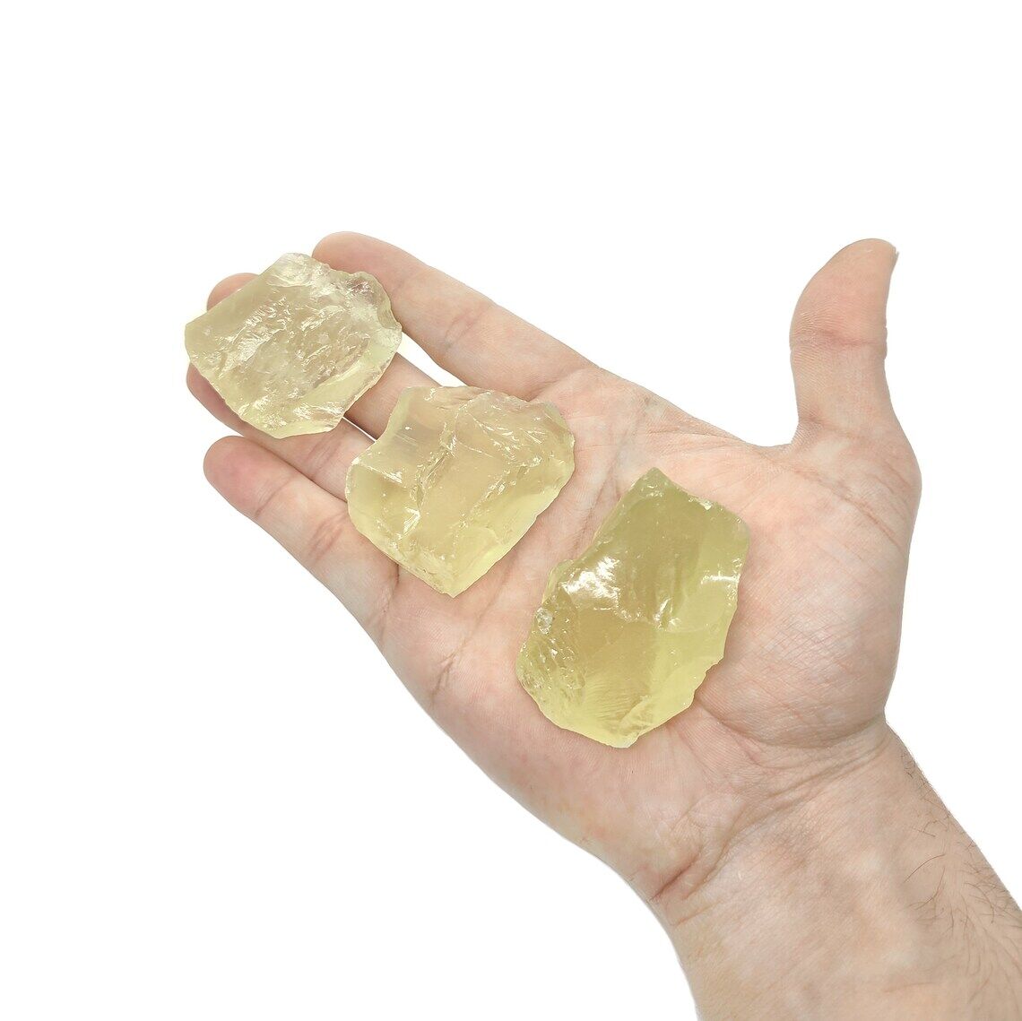 Milchiger, semi-transparenter Citrin Rohstein auf einer Hand.