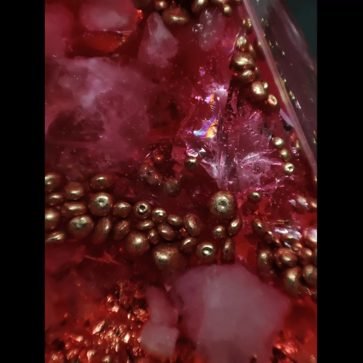 Makroaufnahme einer Orgonit Pyramide mit Rosenquarz & Rosé-Gold.