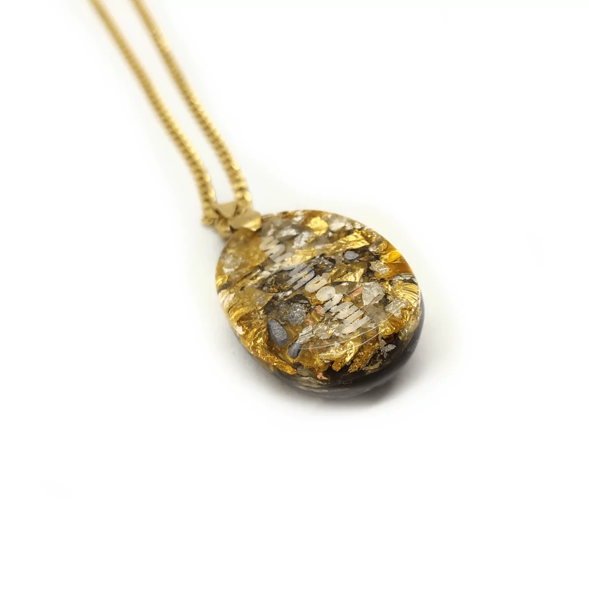 Rückansicht eines Orgonit Schutzamuletts. In den Orgonit ist ein firstonthesun Logo eingearbeitet. Das Orgonit Schutzamulett befindet sich an einer goldenen Kette.