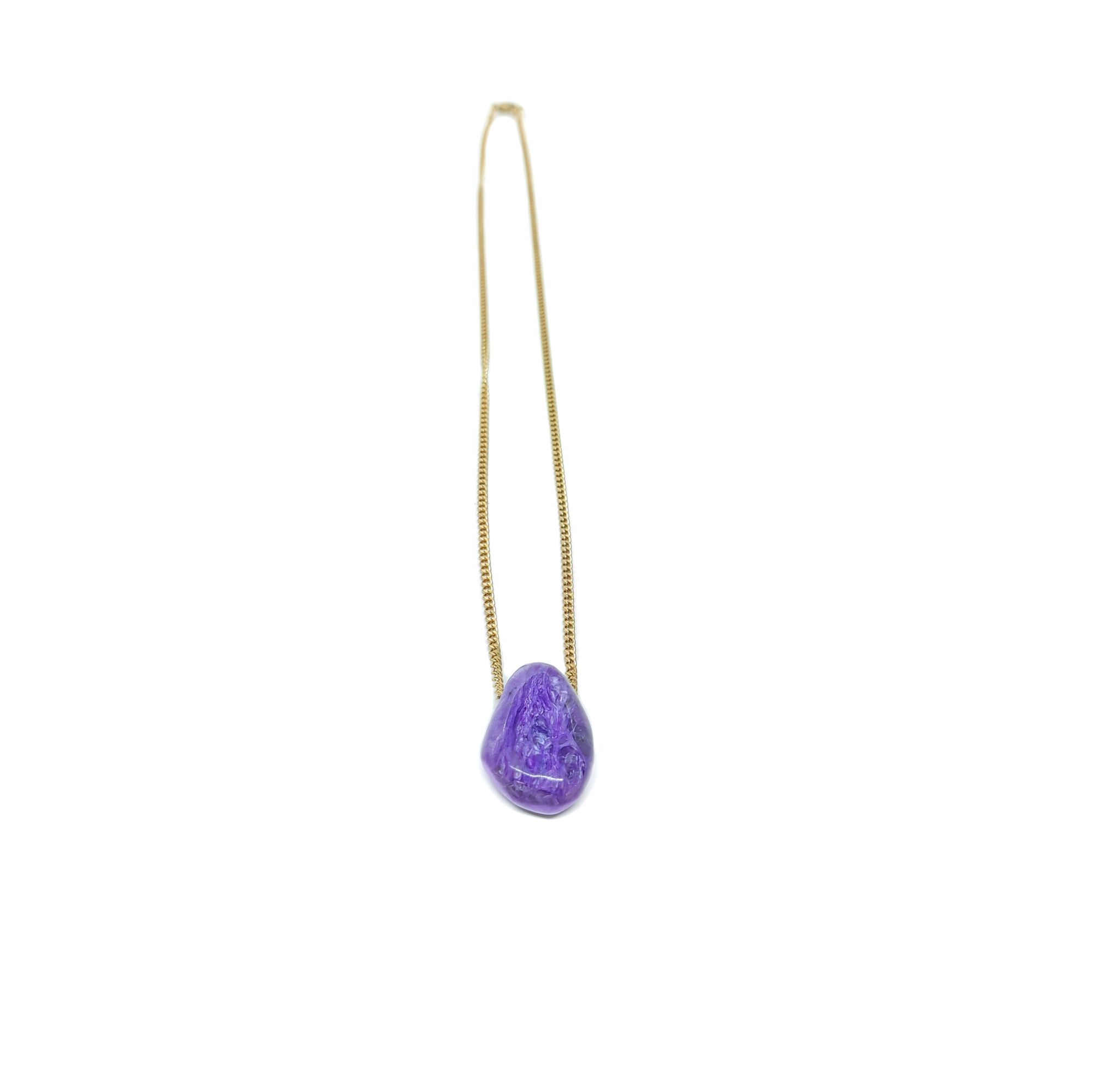 Ein violetter Tropfenanhänger aus dem Edelstein Charoit mit vergoldeter Kette.